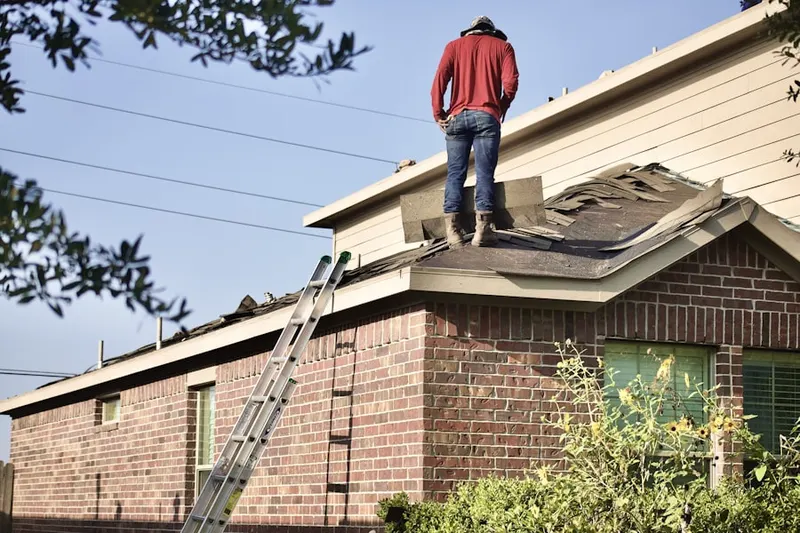 Professional roofer working on a residential roof in Munford
